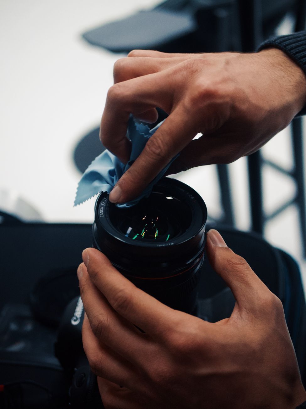Hands cleaning a camera lens