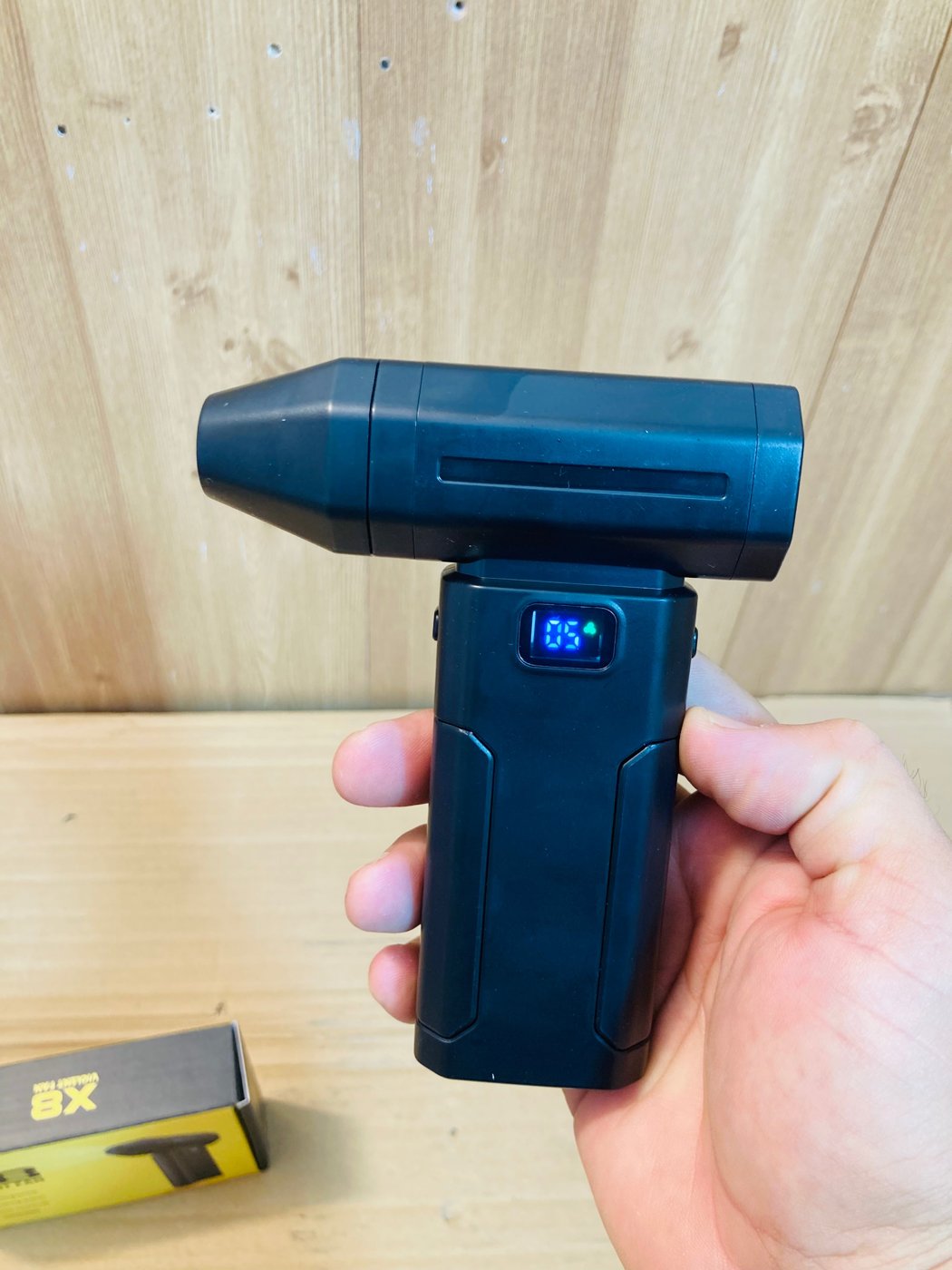X8 Violent Fan held in hand with display lit